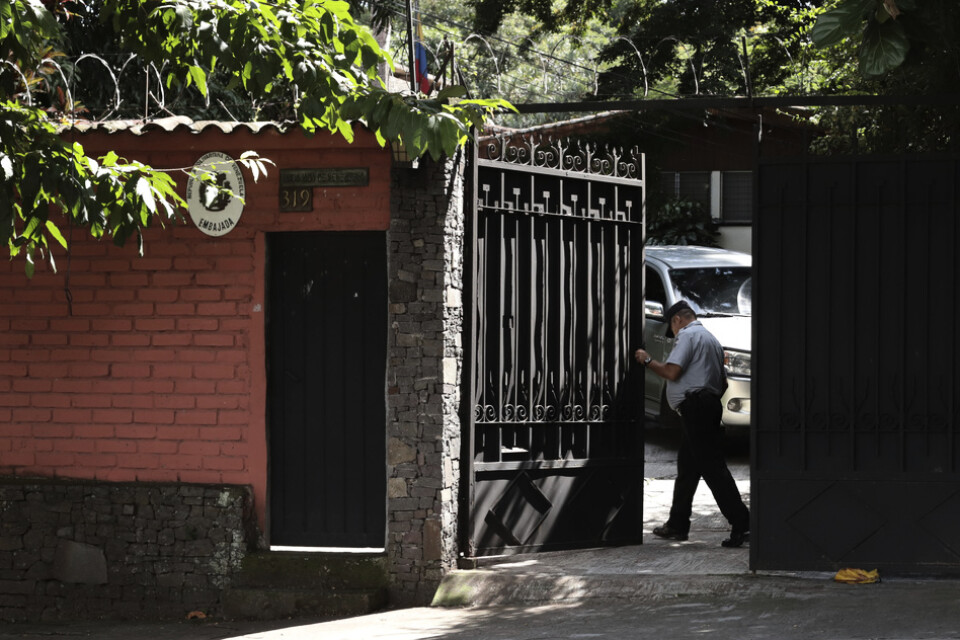 En vakt öppnar grindarna till Venezuelas ambassad i San Salvador i El Salvador.