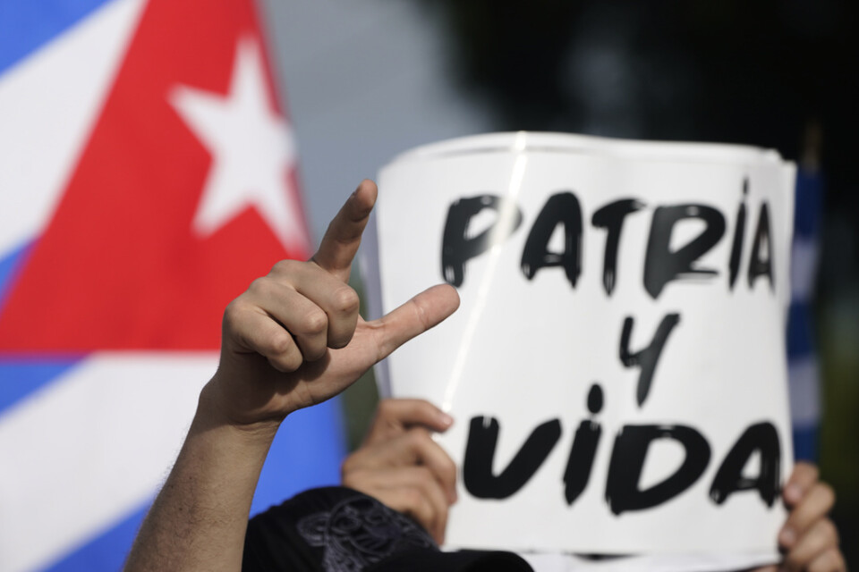 En demonstrant i Miamiområdet Lilla Havanna håller en skylt med orden "fosterland och liv". Sedan låten "Patria y vida" släpptes på Youtube i februari har videon haft nästan sju miljoner visningar.