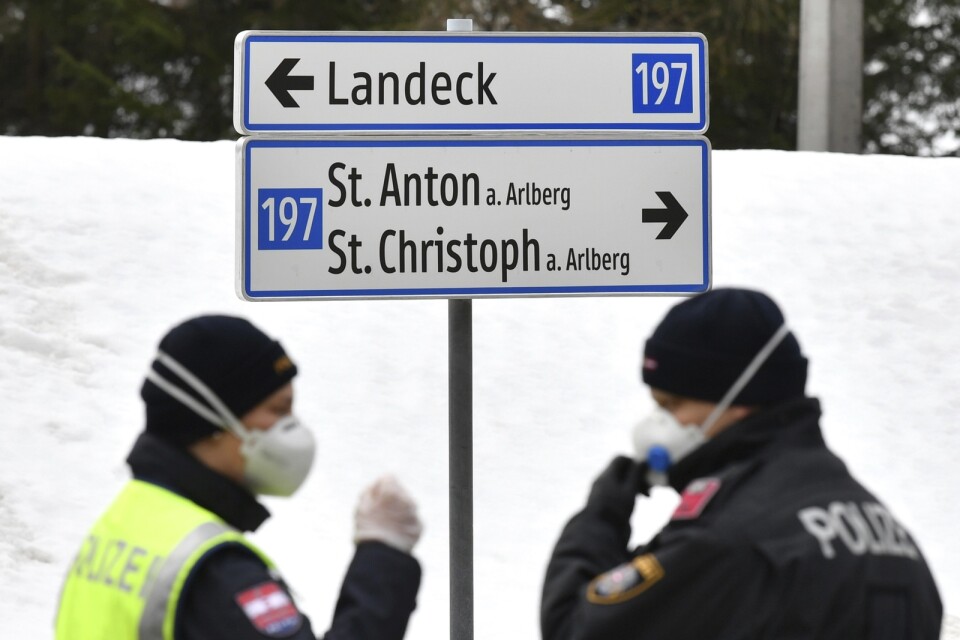 Poliser som bevakar en vägspärr vid infarten till S:t Anton i Tyrolen i mitten av mars, sedan den och andra populära skidorter satts i karantän. Arkivbild