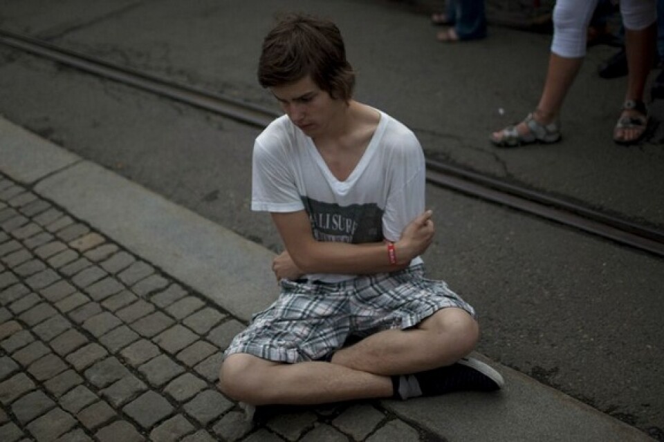 16-åriga Gard Strand sitter utanför domkyrkan i Oslo för att hedra offren. Foto: Scanpix