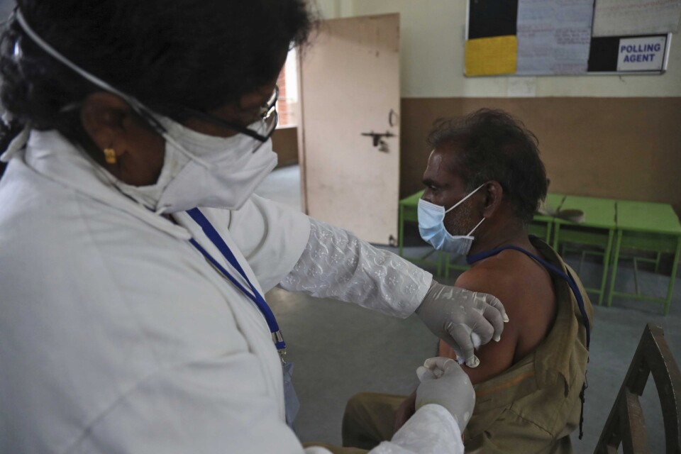 En man får vaccin i indiska Hyderabad. Över 220 miljoner doser vaccin har getts i landet som har en befolkning på omkring 1,4 miljarder människor.