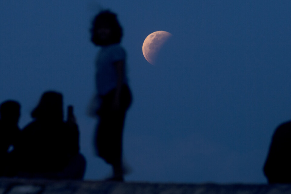 Boende på den indonesiska ön Bali håller ett öga på månen.