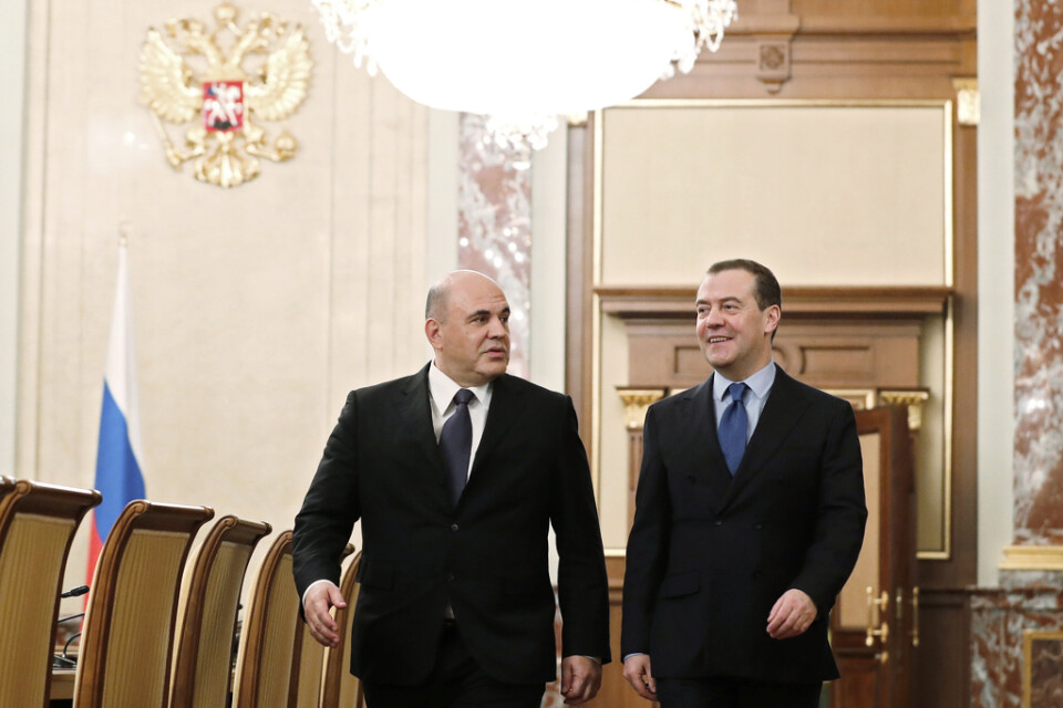 Rysslands nye premiärminister Michail Misjustin (vänster) träffar mannen han efterträder, den omplacerade Dmitrij Medvedev, på fredagen.