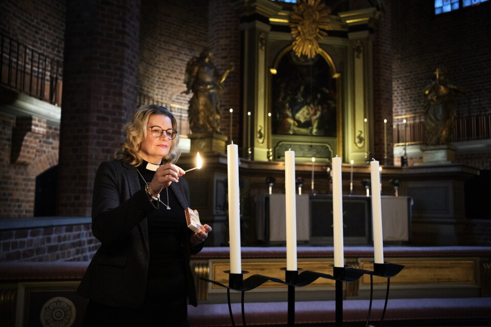 Gina Lindroos tänder ett ljus i adventsljusstaken i Klosters kyrka. I år blir det ingen körsång i advent, men kyrkan står öppen för ljuständning och samtal.