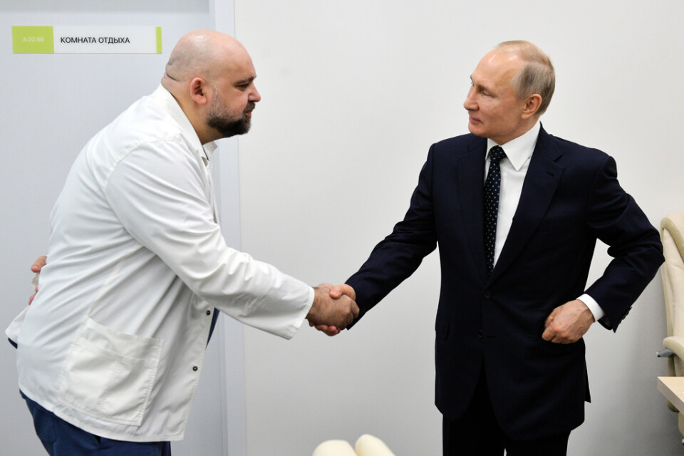 Sjukhuschefen Denis Protsenko skakar hand med Vladimir Putin när presidenten besöker ett sjukhus för coronapatienter utanför Moskva. Bilden togs den 23 mars och några dagar senare testade Protsenko positivt för coronasmittan.