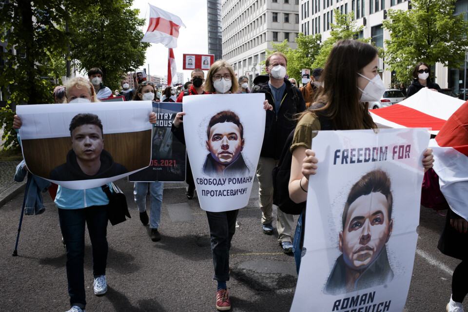 Människor bär plakat med Roman Protasevitjs bild vid en demonstration i Berlin i maj 2021. Arkivbild.