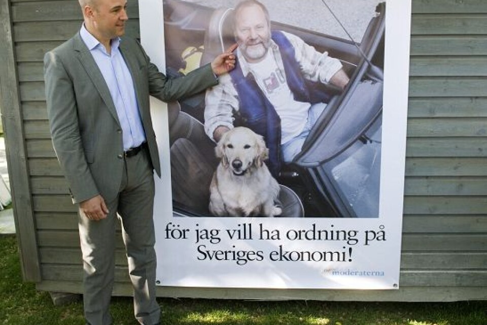 Statsminister Fredrik Reinfeldt framför partiets nya kampanjaffisch. Foto: Henrik Montgomery / SCANPIX