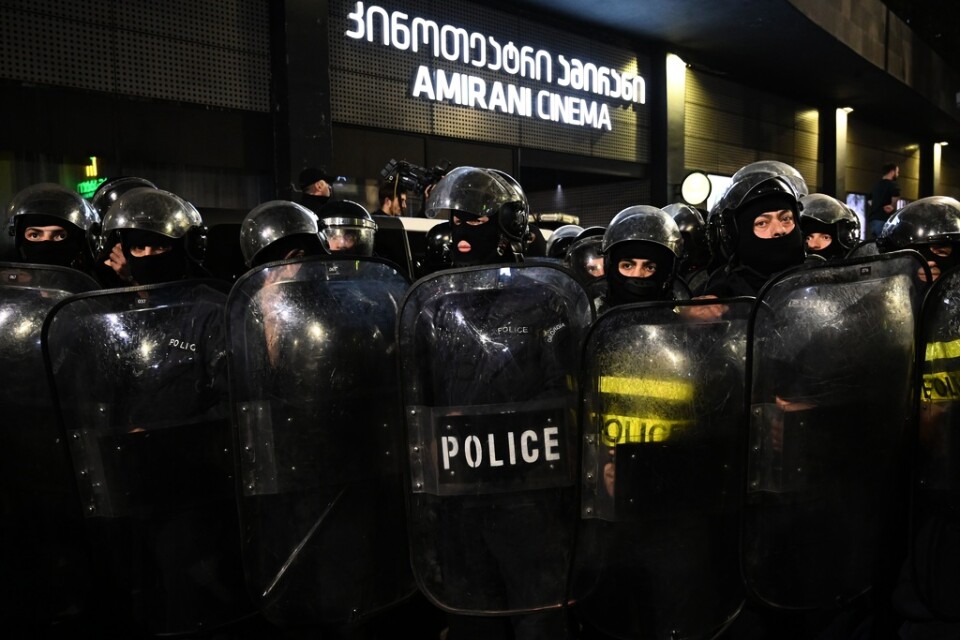 Georgisk polis skyddade dörrarna till Amirani-biografen i Tbilisi mot demonstranter.