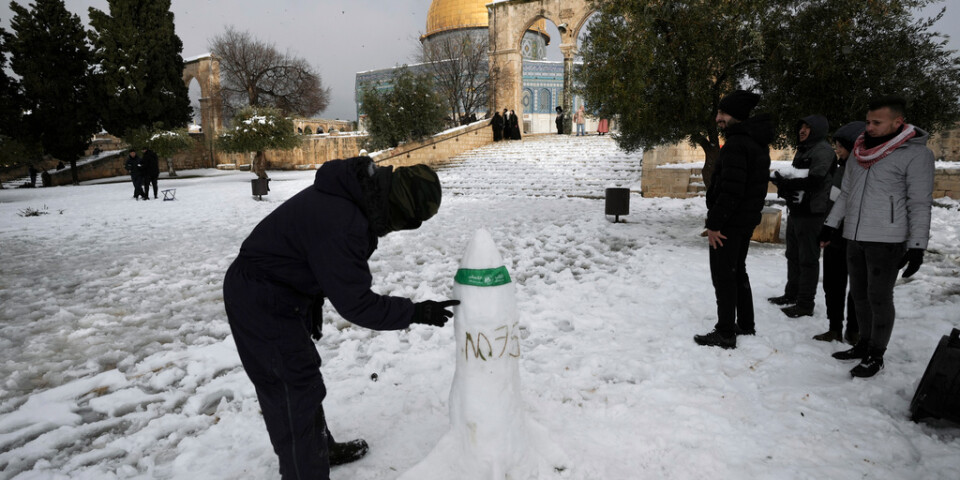 En palestinsk man bygger en snöskulptur i form av en raket vid al-Aqsamoskén.