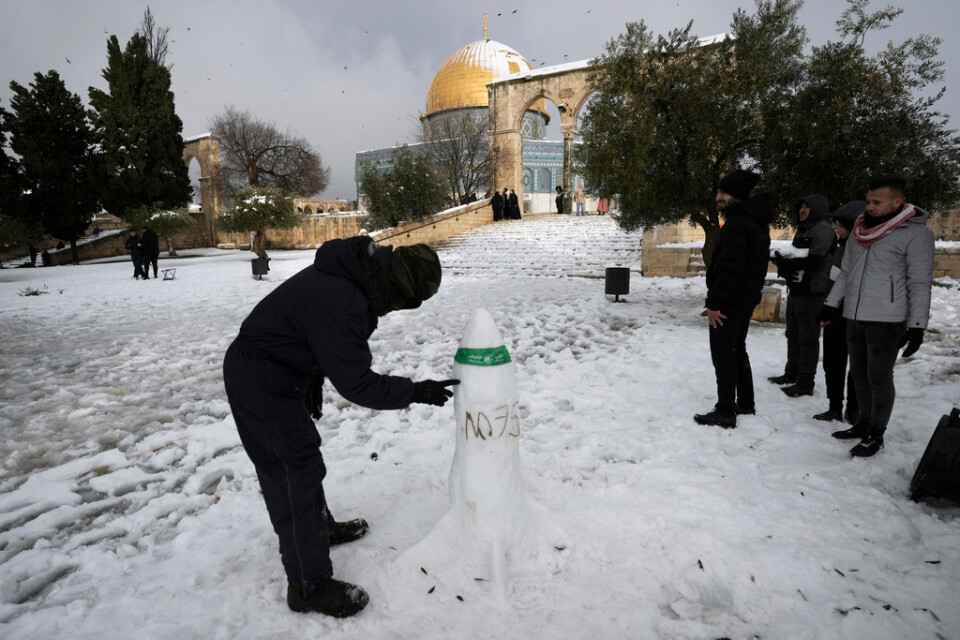 En palestinsk man bygger en snöskulptur i form av en raket vid al-Aqsamoskén.