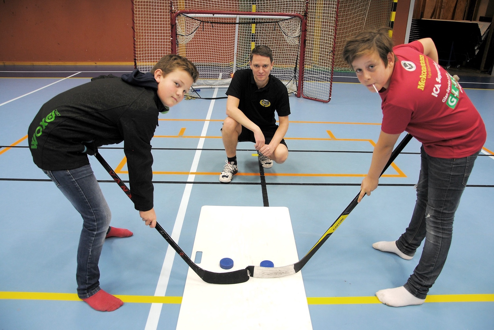 Ludwig Olofsson-Sillberg och Elliot Svensson testar hockey. Lars Dahlquist från Osby IK var på plats och hjälpte ungdomar som var sugna på att testa sina kunskaper med klubba och puck.