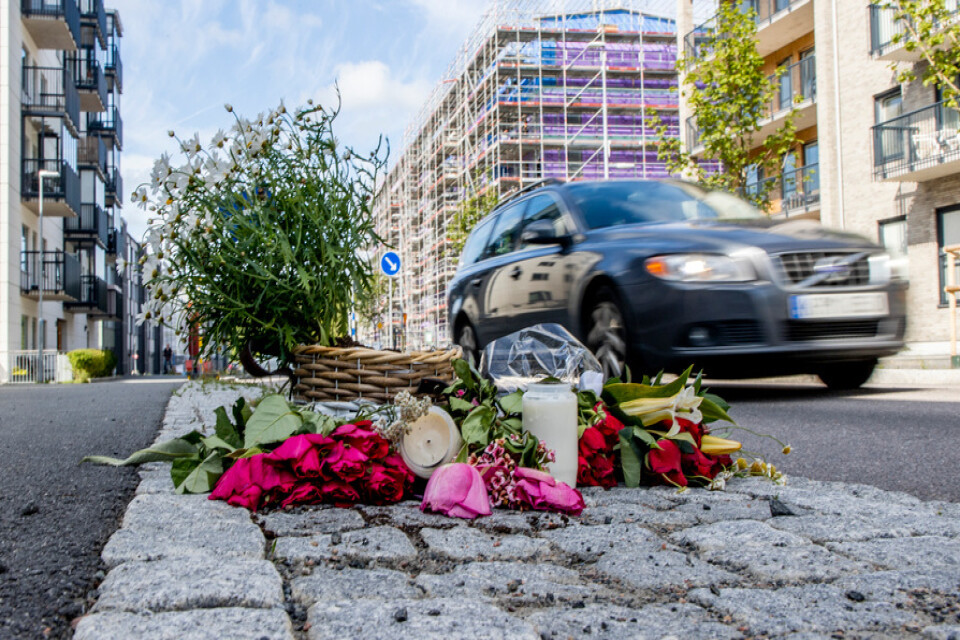 Blommor och ljus på platsen där en kvinna och man blev påkörda, ett par dagar efter händelsen i juli.