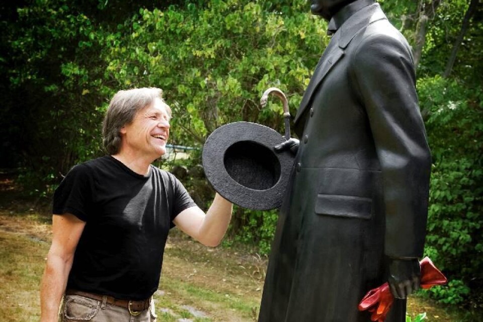 Skulptören Peter Linde vid sin skulptur av Hjalmar Söderberg utanför Kungliga Biblioteket. Foto: Malin Hoelstad