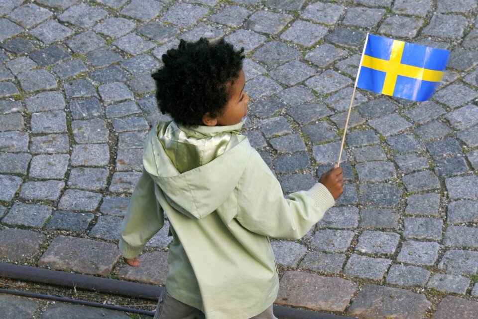 Pojke viftar med svenska flaggan.