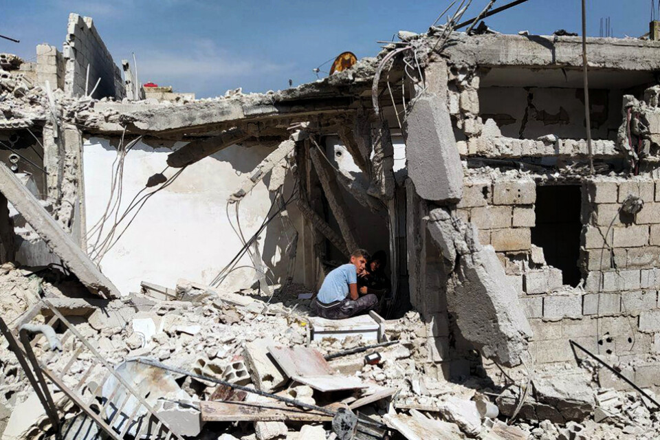 Pojkar leker i en ruin i en förort till det krigshärjade Syriens huvudstad Damaskus.