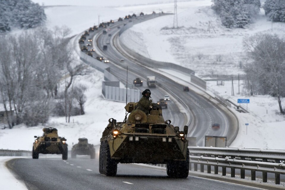 En konvoj av ryska pansarfordon rör sig längs en motorväg på Krimhalvön.Ryssland har mobiliserat uppskattningsvis 100 000 soldater med stridsvagnar och andra tunga vapen nära Ukraina.