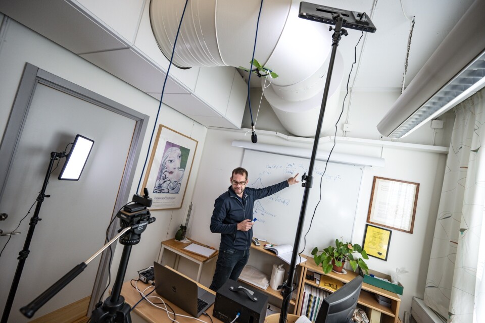 Universitetslektor Kristofer Modig har gjort om sitt arbetsrum på Kemicentrum i Lund till en liten studio. Han kan ha föreläsning för 100 studenter på en gång, men ser bara 18 av dem åt gången på små bilder på dataskärmen.