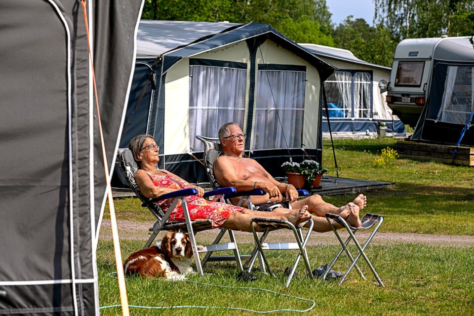 Marita och Leif Strömberg trivs på Bredvikens camping i Figeholm. Vid deras fötter ligger deras hund Pajazzo troget.