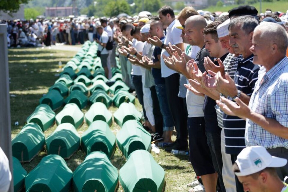 Bosniska muslimer ber framför kistorna med nyupptäckta offer för massakern i Srebrenica 1995.