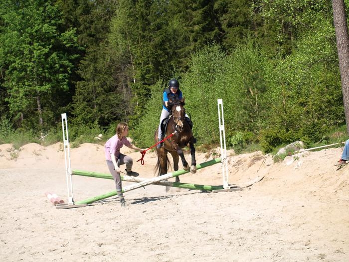 Hopptävling - Cajsa på hästen Danne. Veronica utan häst tar sig över hindret. Fotograf Camilla Fredriksson.
