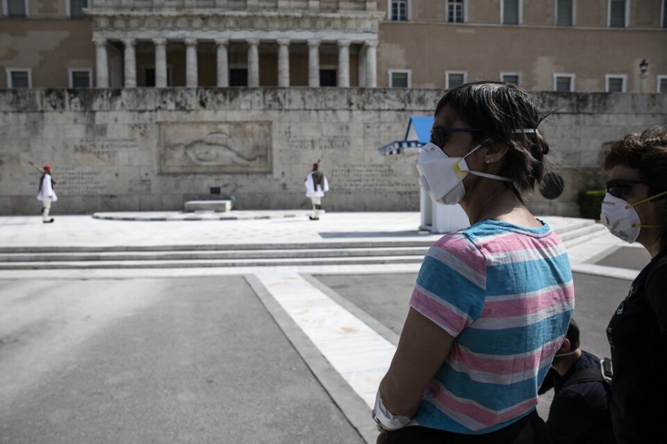 Turister med ansiktsmasker i Aten i mitten av mars – innan utegångsförbudet trädde i kraft.